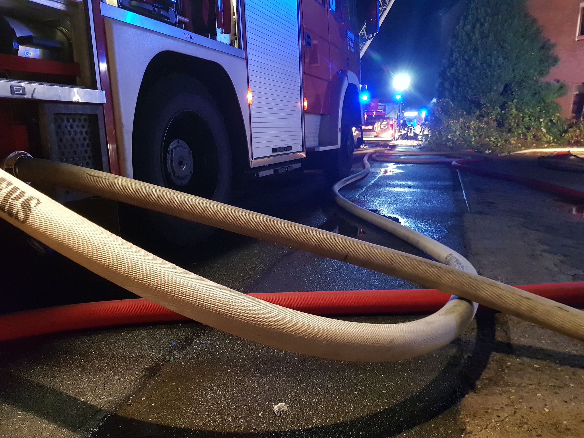 Einsatzfahrzeug und Schlauchleitungen im nächtlichen Einsatz